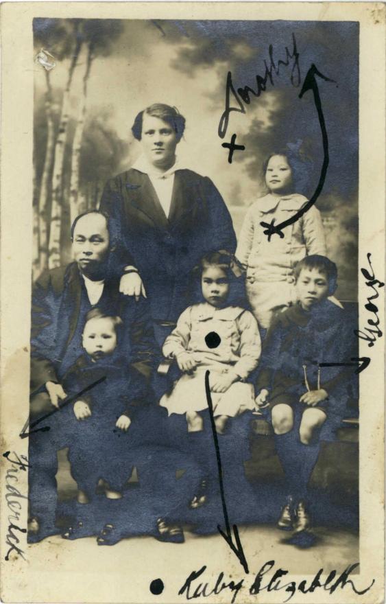 Sepia photograph of Chinese family with written text.