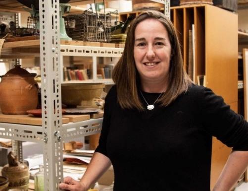 Woman standing in front of shelves with objects