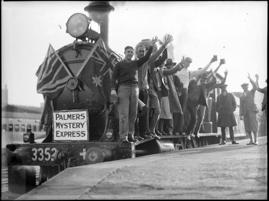 Steam locomotive with people waving.