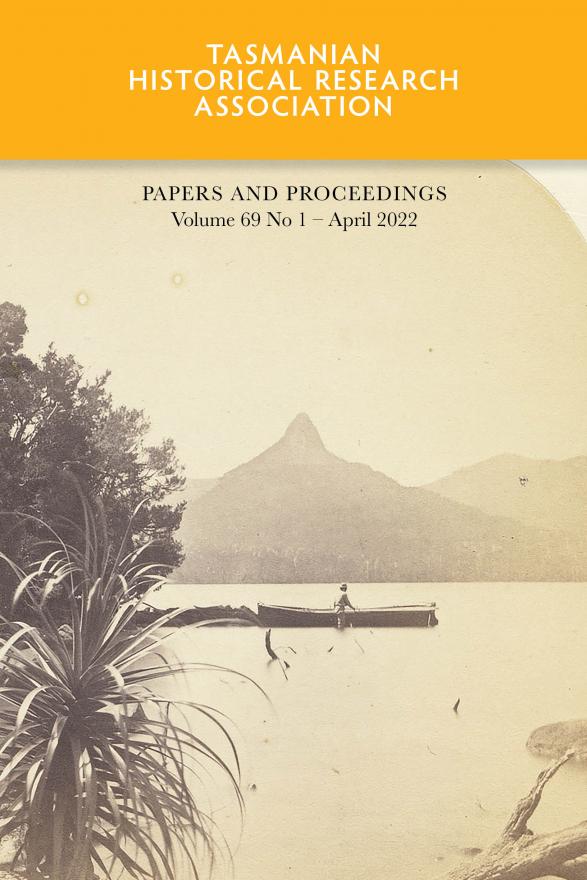Sepia image of person in boat on lake with mountain in background.